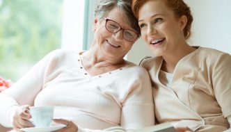 young woman snuggled up with elderly mother