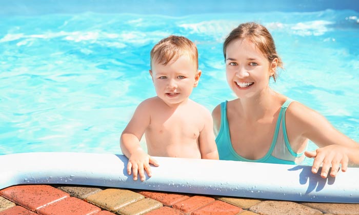 mom with young boy in pool water