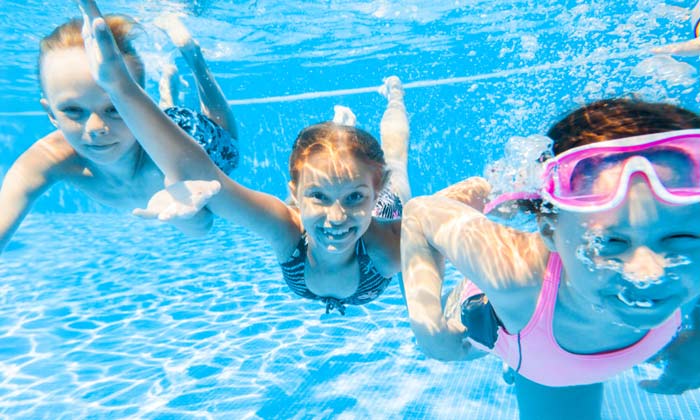 three kids swimming happily underwater
