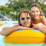girl with father floating on pool water