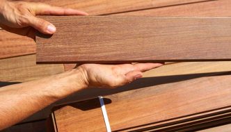 holding up new ipe decking wood boards before installation